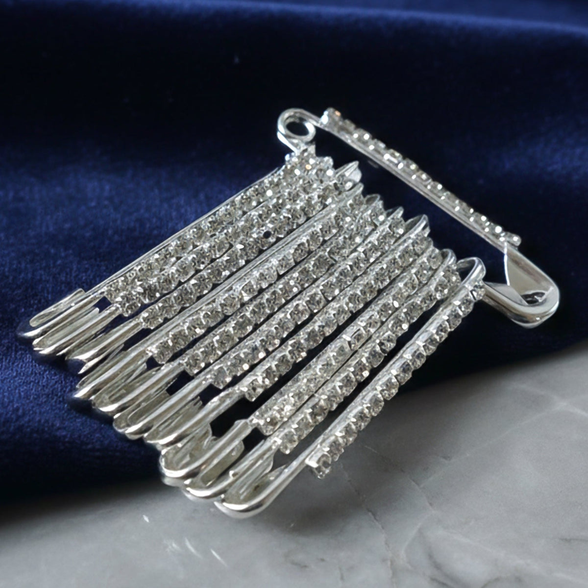 Silver safety pin brooch with crystal attached to a scarf